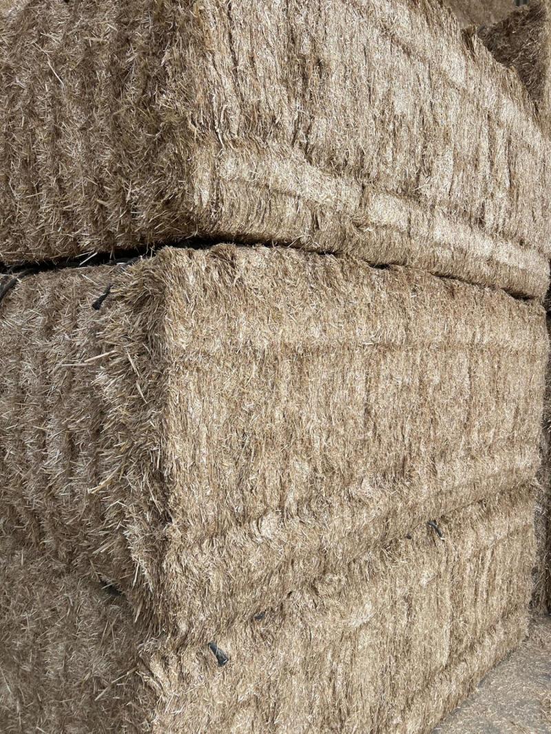 Close-up of a bale of hay with a textured surface.